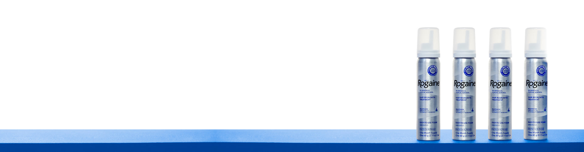 Four bottles of ROGAINE® Men's Topical Foam on a blue shelf with a white background