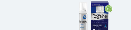 Bottle and box of Men's ROGAINE® Foam Solution on a gray background.