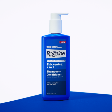 Blue bottle of men's ROGAINE® 2-in-1 Shampoo + Conditioner on a white background