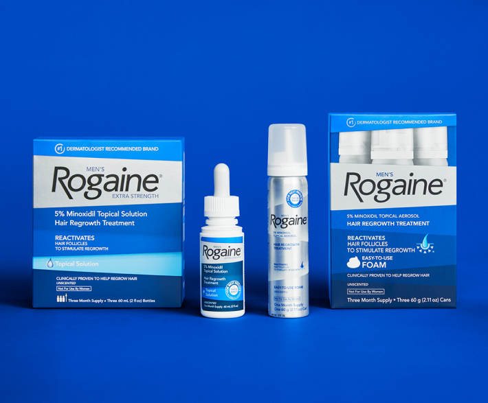 Bottle of Men's Rogaine Topical Solution and Foam with packaging on a blue background.